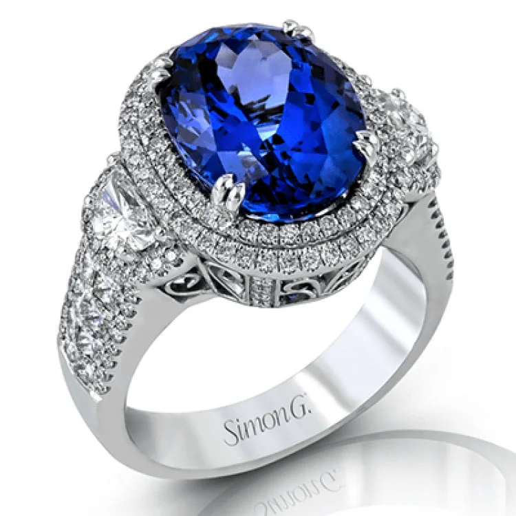 ladies rings with topaz blue -This substantial cocktail ring features an impressive 10.59 ct tanzanite center stone, accented by .73 modified half moon shaped diamonds, .62 ctw princess cut diamonds, and .65 ctw round diamonds.